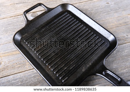 Cast iron griddle pan on wood background