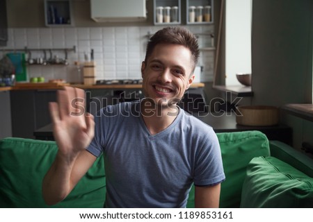 Portrait happy smiling young man waving hand, looking at camera, greeting, saying hello, head shot portrait Royalty-Free Stock Photo #1189853161