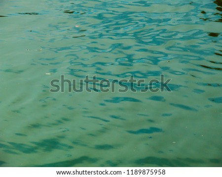 Abstract blue water surface background. Calm sea closeup photo. Fresh wavy water texture. Boat travel banner template. Marine travel wallpaper. Spring or summer relaxing photo. 