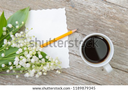 Still life with a cup of coffee and flowers on a wooden table....
