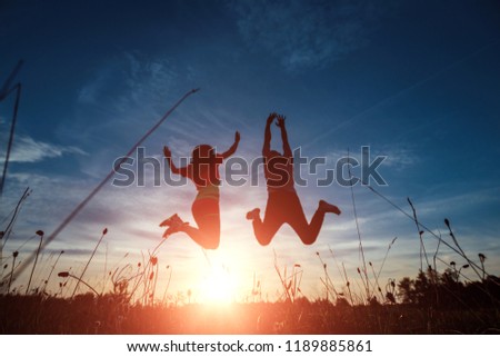 Happy young couple jumping against the beautiful sunset. Freedom, happiness, the concept of pleasure. A symbol of hope, freedom.