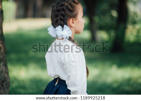 Portrait of happy little girl with two braids ready to go to first day of school