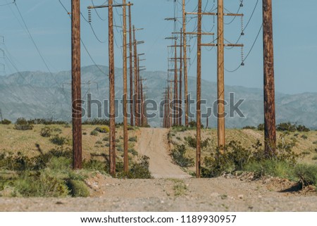 Old power grid dirt road, wooden electric poles	