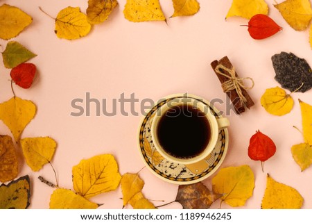Autumn composition. Frame made of autumn leaves. A cup of coffee and cinnamon sticks. Flat lay, top view, copy space