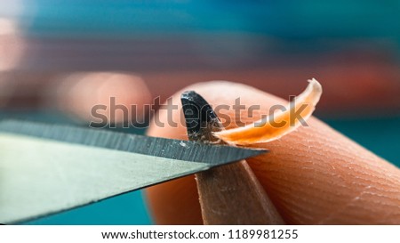 Sharpening blunt pencil with art knife, macro picture focus on blade, tip and finger