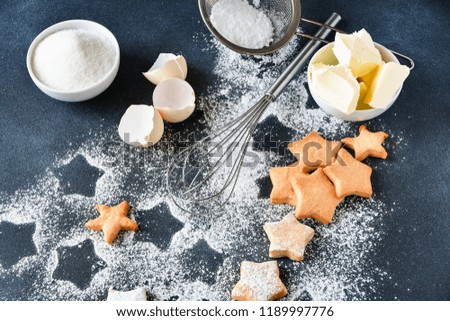 Christmas cookies in the shape of stars, on a dark background of stars and powdered sugar, ingredients for cookies butter, sugar, flour. preparation for Christmas 2019 and new year 2019