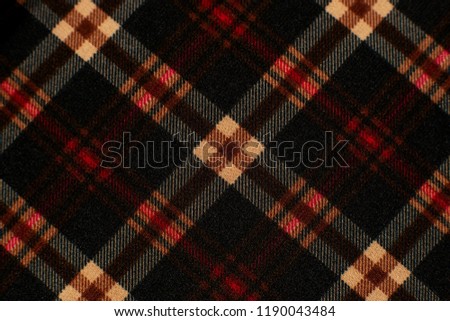 Checkered fabric for the costume. Texture of wool fabric for sewing clothes. Checkered colorful fabric creates a background. Fashion, style and design of textiles.