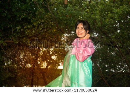 Portrait of Asian woman pose of standing in Korean Hanbok dresses on tree background.