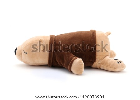 Sleepy stuffed sloth is laying and isolated on a white background for designs