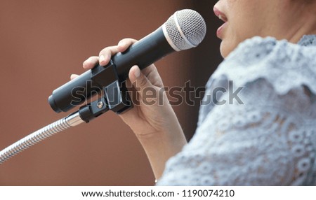 The woman is taking the speech and holing the microphone.