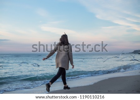 Back portrait girl running on sea beach in stylish wear, stylish wear, skin care, brunette hipster enjoy the sea, happy model, dreamer, girl running to seagulls, bohemian woman resting, hand watch