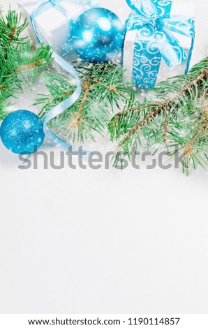 Christmas decorative background with fir branches, cones, silver and blue christmas  ball and tojs, gifts and ribbinon the white background. card Holiday Concept. copy space, top view.