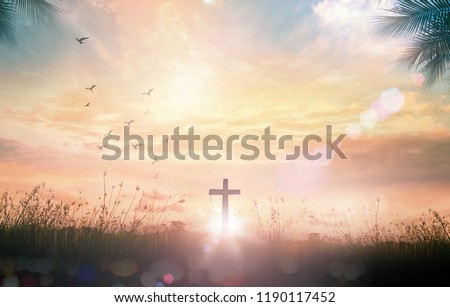 Good Friday concept: Silhouette cross on meadow autumn sunrise background