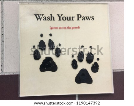 A amusing sign outside a public convenience telling people to wash their paws