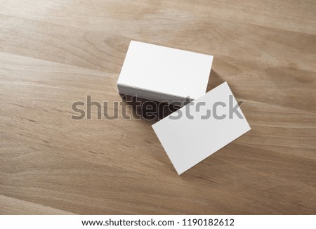 Blank white business cards on wood table background. Mockup for branding identity. Template for graphic designers portfolios.