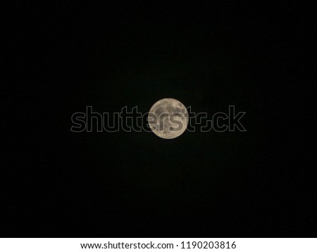 full moon with clouds around in shades of colors