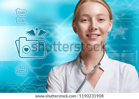Electronic Health and Medical Records concept. A young woman doctor, is feeling confident in front of a virtual augmented reality screen, as it displays an organised folder system of medical records
