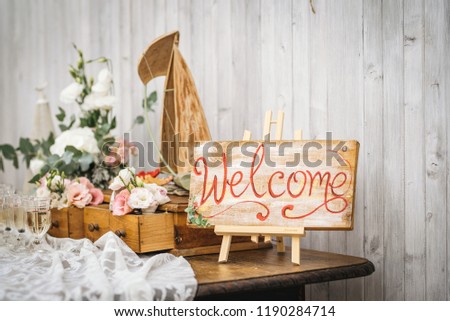 Wooden hand-written welcome sign. Rustic style