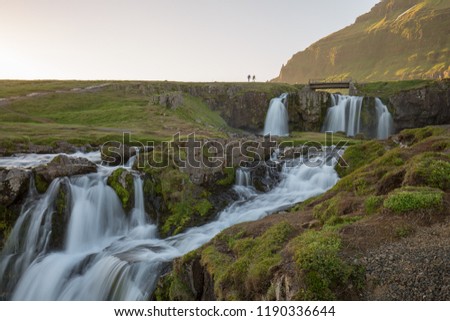 a waterfall in iceland between the mountains from the river spring