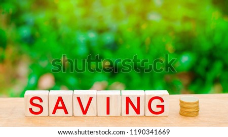Blocks with the inscription "Saving" and a coins. The concept of investment in a business project, the purchase of real estate, at home. Financial Accounting and Economics. property ladder, mortgage