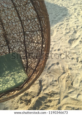Hanging chair with green pillow on the sandy beach at sunny day Royalty-Free Stock Photo #1190346673