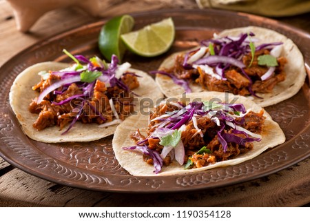 Three delicious pulled pork tacos with cabbage, onion and cilantro. Royalty-Free Stock Photo #1190354128