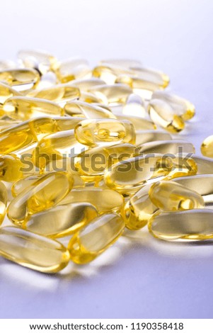 Capsules of fish fat oil on a white background with space for text