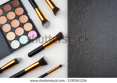 Creative arrangement of cosmetics one white and black textured background. Copyspace for text. Flat lay or top view.         