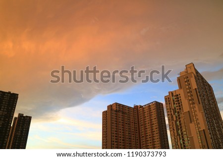 Rain clouds with sunset afterglow reflections scrolling on the high buildings