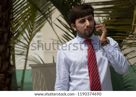 Businessman standing outdoors and talking on mobile phone