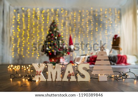 Wooden letters Xmas on the christmas tree background