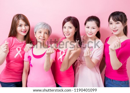 women with breast cancer prevention and show heart gesture on the pink background