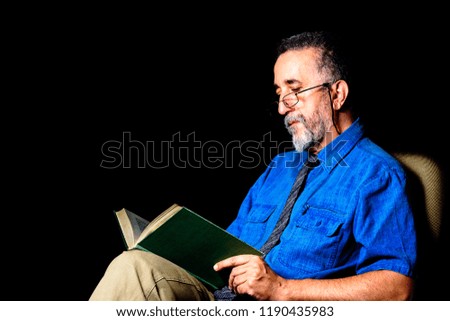 
Adult man with tie and glasses reading an old book