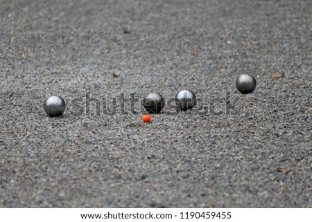 Petanque playing in a rocky field.