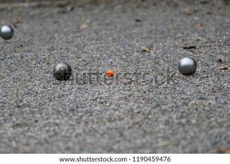 Petanque playing in a rocky field.