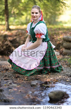 Young beautiful slovak woman in traditional costume on summer