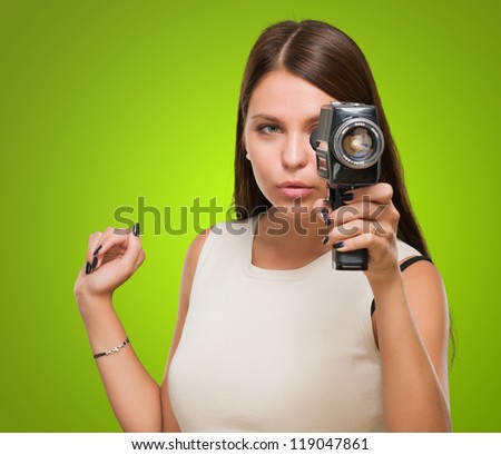 Young Woman Holding Camera against a green background