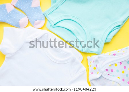Baby yellow booties. Children's shoes and toys on yellow background. Newborn. Top view