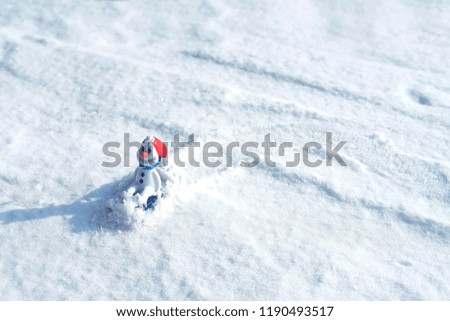 Beautiful snowman on natural snowdrift. Little funny white snowman in the snowbank.