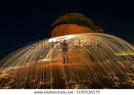 Hot Golden Sparks Flying from Man Spinning Burning Steel Wool in Desert Area.