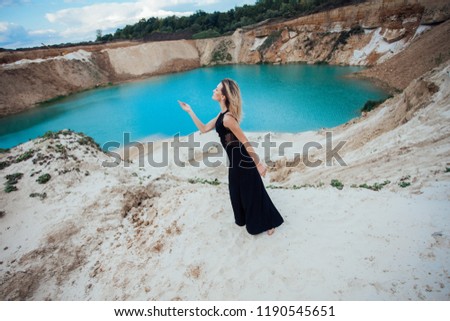Girl stands by the blue lake