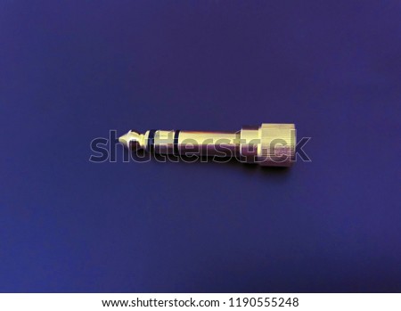 Audio plug (jack) connector for music on blue background.