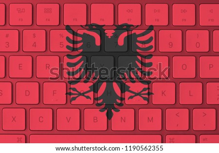 Albanian flag and computer keyboard in the background. Albania flag