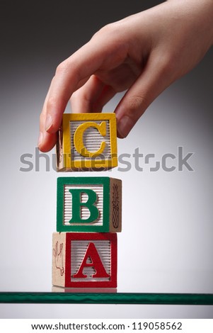 kid reaching for ABC blocks