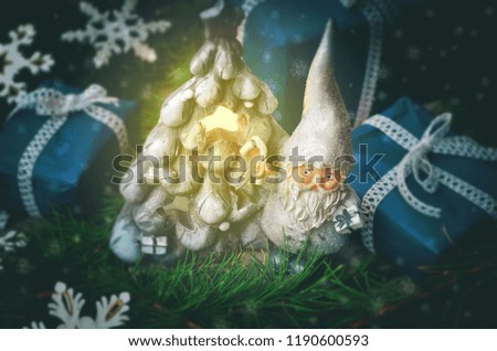 Christmas background with toy gnome, gifts and fir tree on a dark background. toning. selective focus