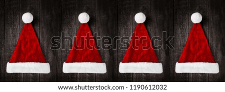 Santa Claus helper hats on rustic wooden background. Christmas and New Year celebration

