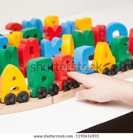 Russian wooden letters train alphabet with locomotive. Bright colors of red yellow green and blue on a white background. Early childhood education, learning to read, preschool and kids game concept