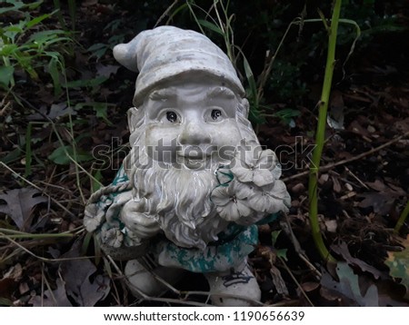 garden gnome sitting in the garden on a cool fall day