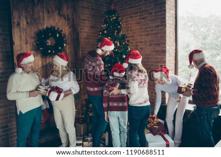 Full diverse family, noel gathering, meeting, tradition, custom. Grey-haired grandparents, grandchildren, sister, brother, daughter, son in hats opening, changing gift boxes in house near tree fun joy
