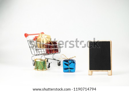 CHRISMAS SALE Concept.Empty Chalkboard with mini shopping cart full of christmas toys and gifts isolated over white background.Copy Space.